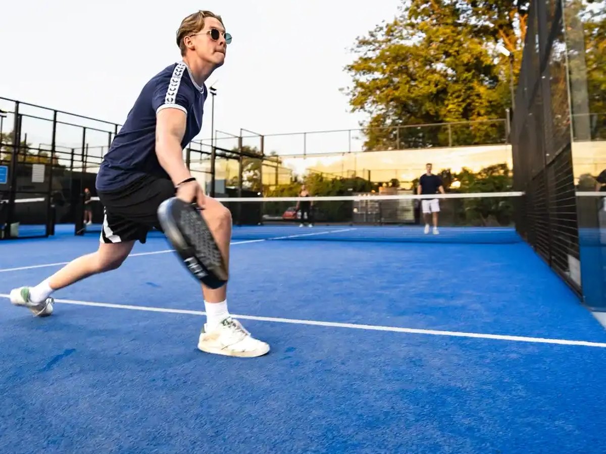 Padel action near the glass wall